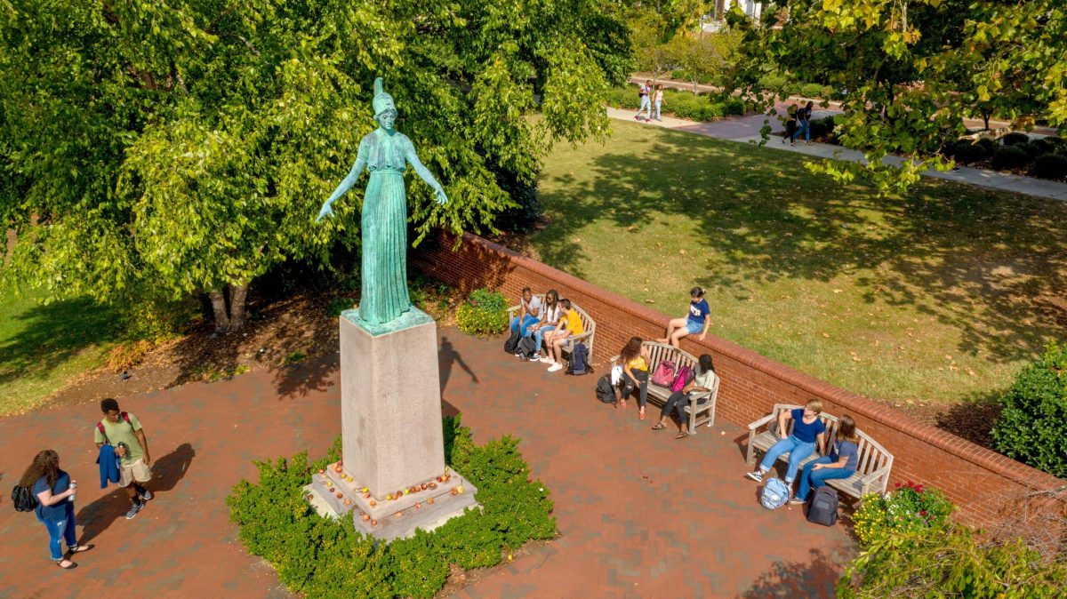 Students gather near the Minerva statue on the UNCG campus.