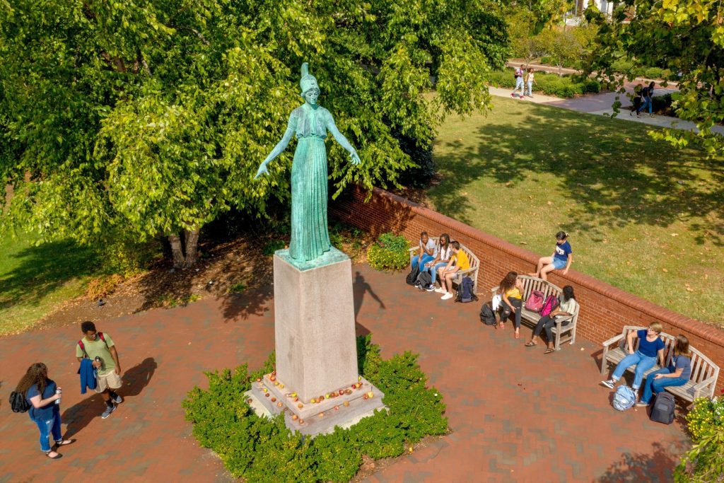 Students gather near the Minerva statue on the UNCG campus.