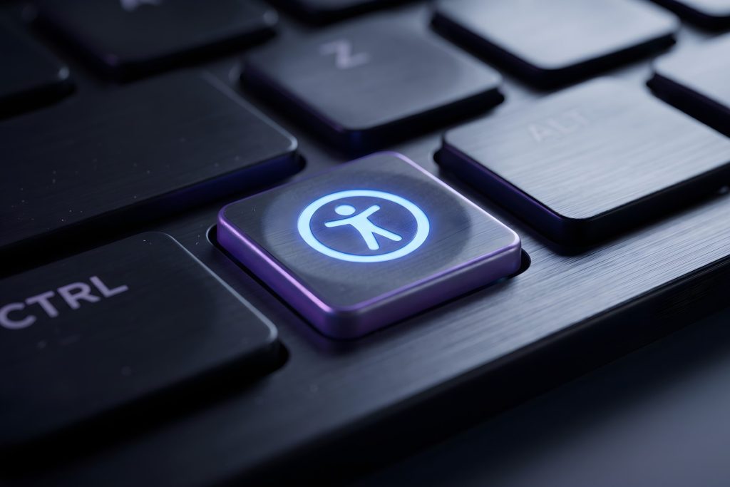 Close-up of a computer keyboard with an illuminated accessibility symbol key.