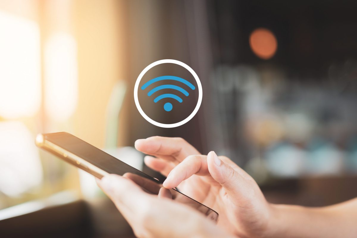 Decorative illustration of a person using a smartphone with a Wi-Fi symbol.